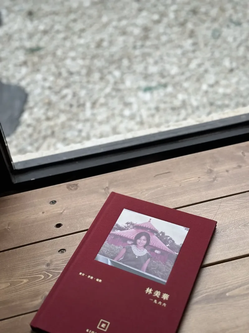 布面精裝嘅長輩故事書,封面嵌住一張舊相,擺喺木枱上